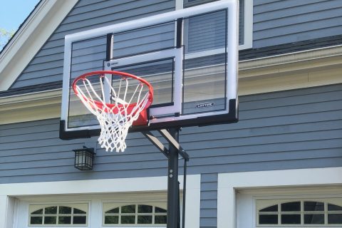 Portable LifeTime basketball hoop in front of a 2 door garage